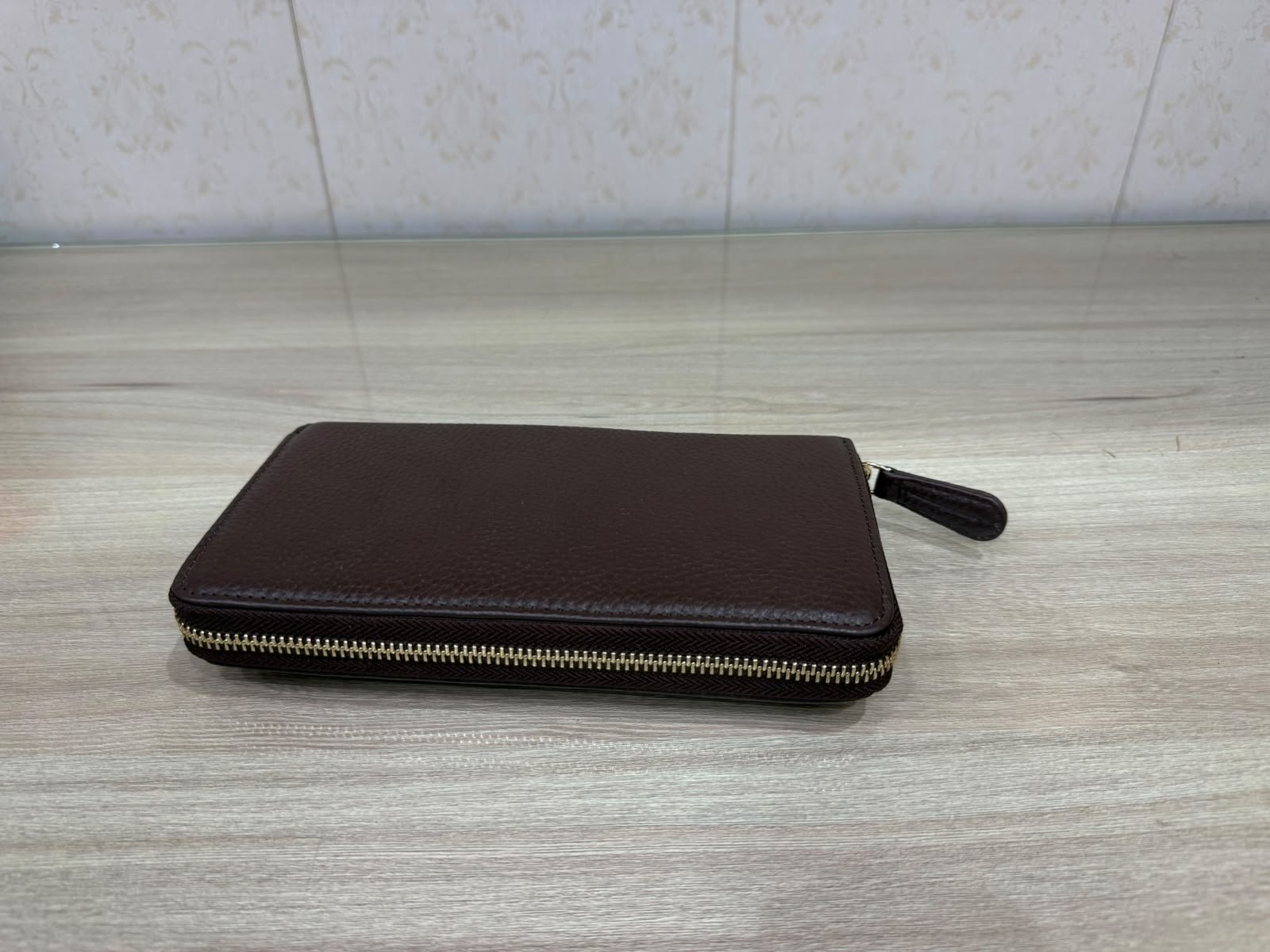 Dark brown leather zip wallet with gold hardware